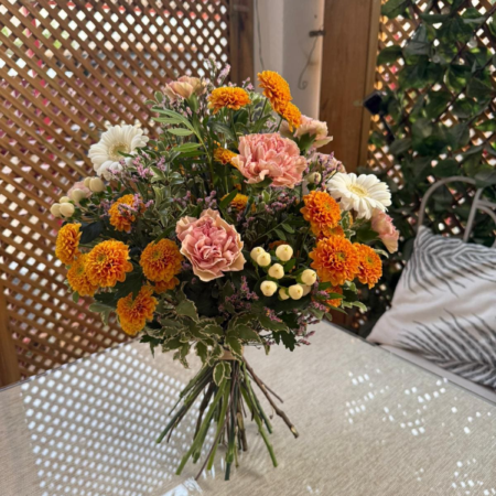Ramo Mandarina con margaritas naranja, claveles crema, gerberas blancas e hipericum, diseño floral Soulgarden.